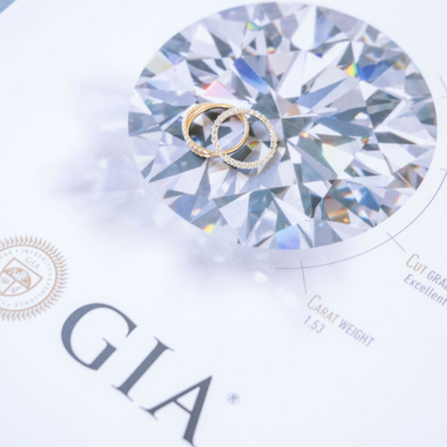 GIA certification pamphlet with two gold rings surrounded in diamonds